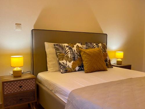 a bedroom with a bed with pillows and two lamps at Iras in Samos