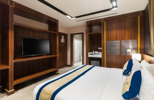 Una cama o camas en una habitación de Al Malqa Elite Hotel