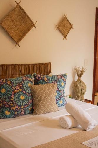 a bedroom with a bed with pillows at Mar Ilha Pousada in Itacaré