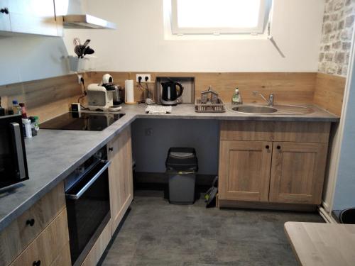 a kitchen with a sink and a counter top at Coquelicot in Criquetot-lʼEsneval
