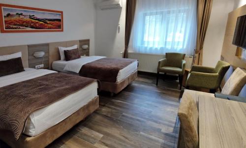 a hotel room with two beds and a chair at Tourist Resort Ribarsko Ostrvo in Novi Sad