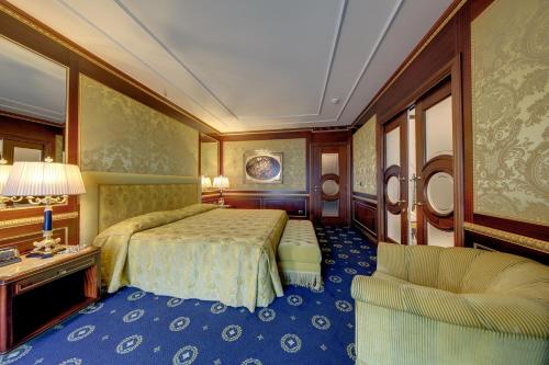 a hotel room with a bed and a chair at Hotel Splendid in Baveno