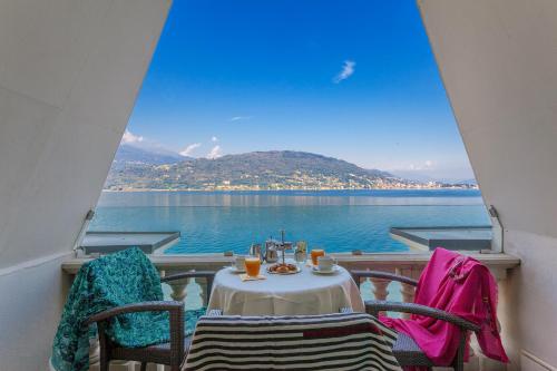 a table and chairs on a balcony with a view of the water at Hotel Splendid in Baveno