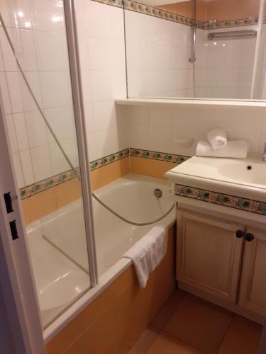 une salle de bain avec une douche, une baignoire et un lavabo dans l'établissement les Restanques Du Golf de Saint Tropez, 83310 Grimaud, France Appartement, à Grimaud