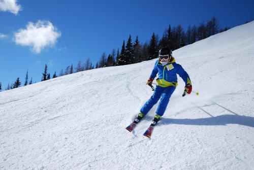 a person is skiing down a snow covered slope at Apartament Na Wierchu in Murzasichle