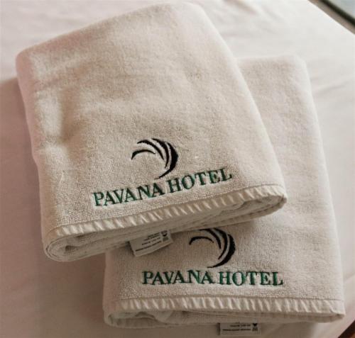 a pile of towels sitting on a bed at Pavana Hotel in Negombo