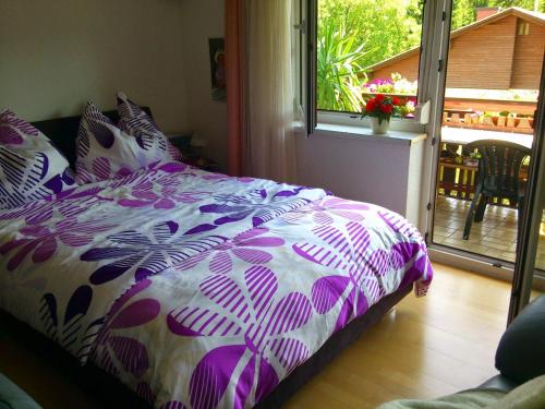 a bedroom with a bed with a purple and white comforter at Appartement Draublick in Unterpudlach