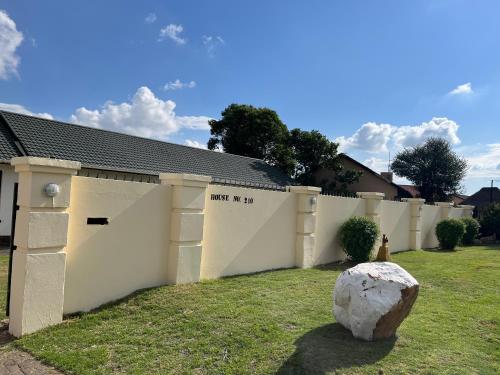 a white fence with a rock in the yard at House 210 holiday rentals in Alberton