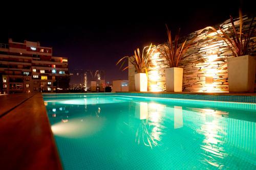 a large swimming pool at night with lights at Rosedal Suite in Buenos Aires