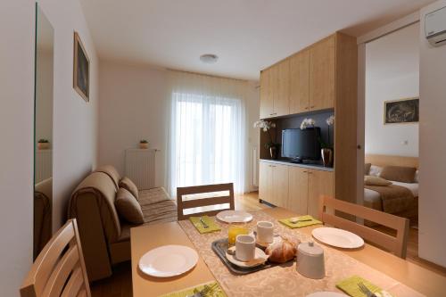 a kitchen and living room with a table and a living room at Postojna Cave Rooms & Apartments Proteus in Postojna