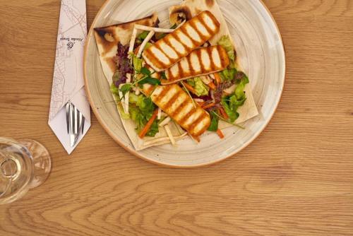 a plate of food with a salad on a table at Tourist Resort Ribarsko Ostrvo in Novi Sad
