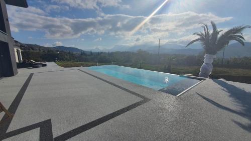 einen Pool mit einer Palme neben einem Haus in der Unterkunft Studio indépendant vue magnifique et au calme in Crest