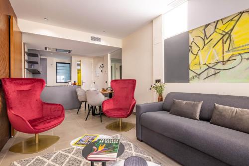 uma sala de estar com um sofá e cadeiras vermelhas em Home Art Apartments Soho em Málaga