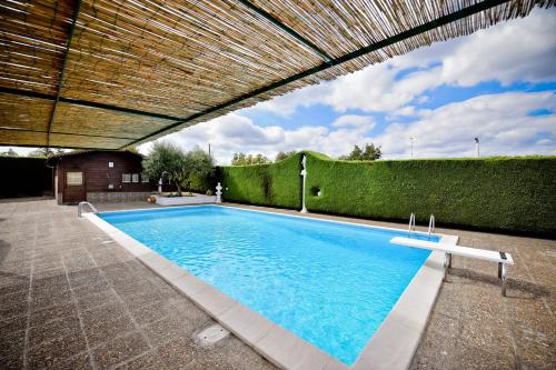 einen Pool unter einem Holzdach mit Pool in der Unterkunft I CINQUE TRULLI with Swimming Pool in Martina Franca