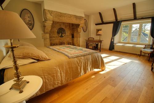 een slaapkamer met een bed en een stenen open haard bij KERBELEG, ferme-manoir du XVè siècle, chambres grand confort in Riec-sur-Bélon