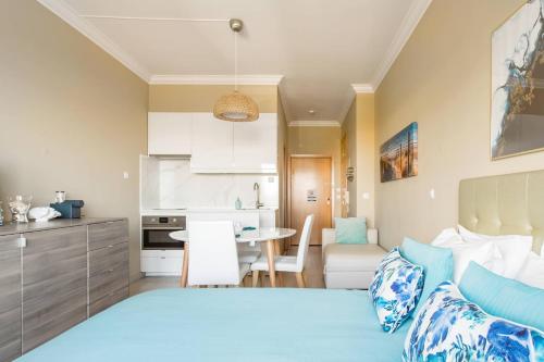 a bedroom with a bed and a kitchen with a table at Beach House Ericeira in Ericeira
