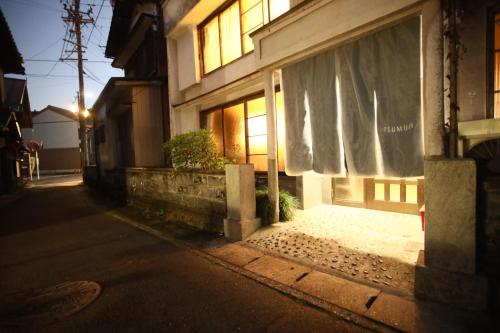 a building with a window with a curtain on a street at コミュニティカフェ民泊つむぎ in Gero
