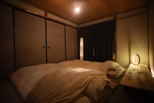 A bed or beds in a room at コミュニティカフェ民泊つむぎ