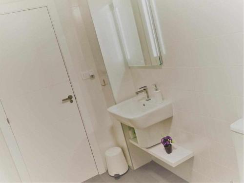 biała łazienka z umywalką i prysznicem w obiekcie San José Apartamentos Turísticos Karlie w mieście Albacete