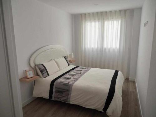 sypialnia z dużym łóżkiem i oknem w obiekcie San José Apartamentos Turísticos Karlie w mieście Albacete