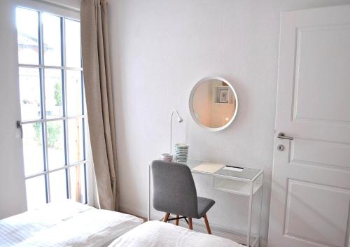 a bedroom with a desk and a chair and a mirror at Malvasia Apart in Stumm