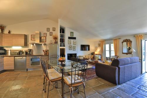 - un salon avec une table en verre et un canapé bleu dans l'établissement Les Arcades, à Villecroze