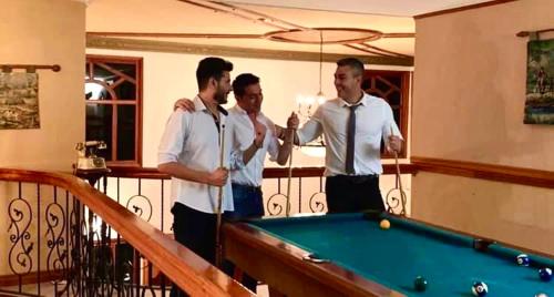 three men standing next to a pool table at Villa Ilusion in San Jerónimo