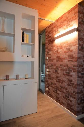 a kitchen with a brick wall and white cabinets at Al Leone di San Marco LUXURY & RELAX in Noale