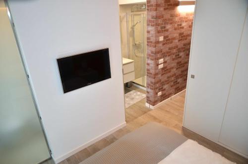 a living room with a television on a wall at Al Leone di San Marco LUXURY & RELAX in Noale