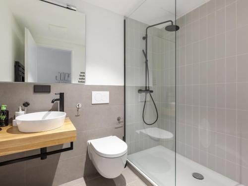 a bathroom with a shower and a toilet and a sink at Limehome Bremen Hutfilterstraße in Bremen