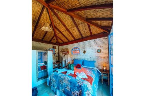 a bedroom with a blue bed and a brick wall at Chalé do Lago super Luxo in Cunha