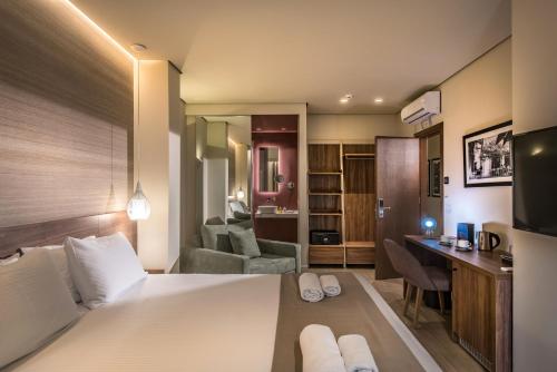 a bedroom with a bed and a desk in a room at Metropole Urban Hotel in Heraklio Town