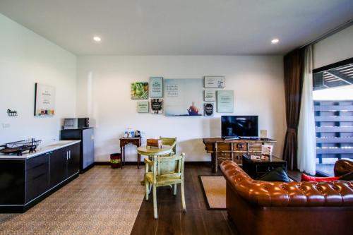 a living room with a couch and a table at Rain Tree Khao Yai Hotel in Phayayen