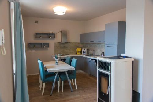 a small kitchen with a table and blue chairs at "Country House il Brolo" in Polpenazze del Garda