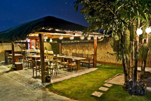 restauracja ze stołami, krzesłami i ogrodzeniem w obiekcie AA TRAVELLERS PAD w mieście Laoag