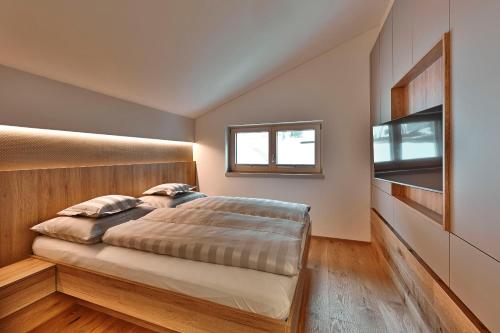a bedroom with a bed and a window at Appartements Täli in Lech am Arlberg