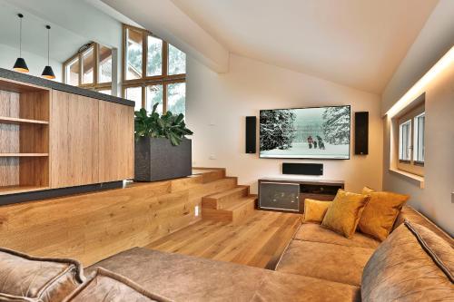 a living room with a couch and a flat screen tv at Appartements Täli in Lech am Arlberg