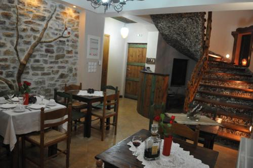 un restaurante con mesas y sillas y una escalera en Pasithei, en Karpenisi