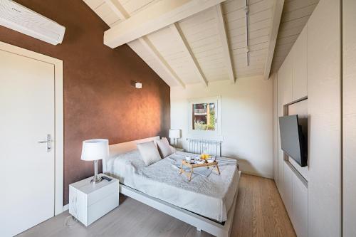 a bedroom with a bed with a table and a tv at Birdie 59 Apartment by Wonderful Italy in Soiano del Lago
