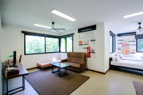 a living room with a couch and a table at Rain Tree Khao Yai Hotel in Phayayen