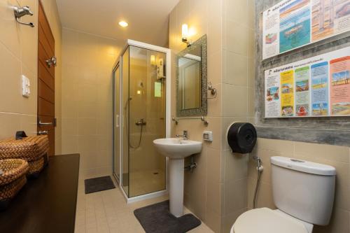 a bathroom with a toilet and a sink and a shower at Rain Tree Khao Yai Hotel in Phayayen