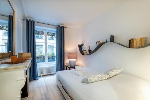 une chambre avec un lit blanc avec une grande fenêtre dans l'établissement Isadora - Ravissant T2 au coeur de Lyon, à Lyon