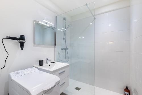 une salle de bain blanche avec une douche et un lavabo dans l'établissement Isadora - Ravissant T2 au coeur de Lyon, à Lyon