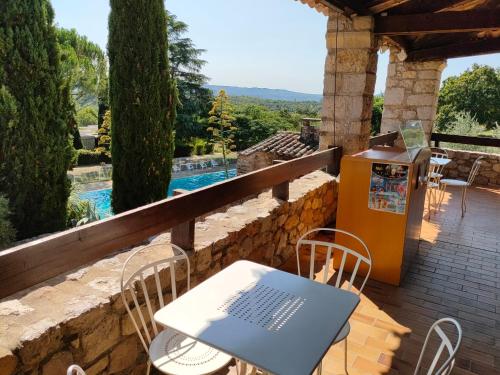 d'une table et de chaises sur un balcon avec piscine. dans l'établissement Residence Vacances Bleues Lou Castel, à Casteljau