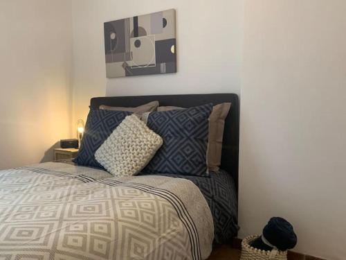 una camera da letto con un letto con cuscini di Esprit Hygge à Blois : un intérieur bien-être a Blois