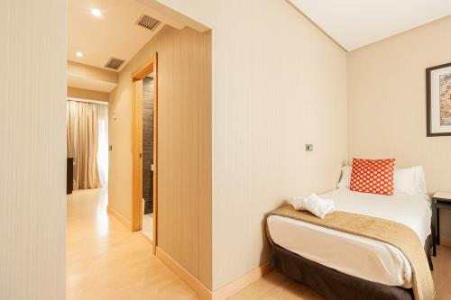 a small bedroom with a bed and a hallway at Oh Nice Ulises Ceuta in Ceuta