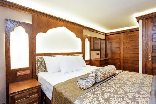 a bedroom with a bed in a room with wooden walls at Kumluk Konak Hotel in Istanbul