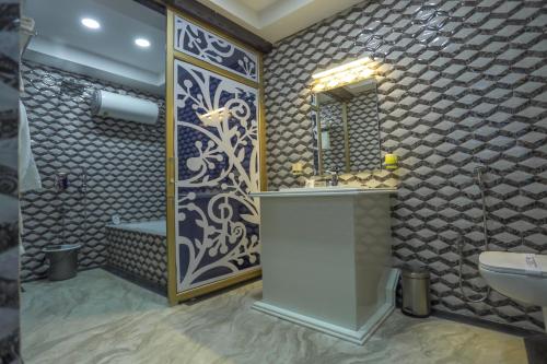 uma casa de banho com um lavatório, um espelho e uma banheira em Hotel Prova em Kuch Bihār
