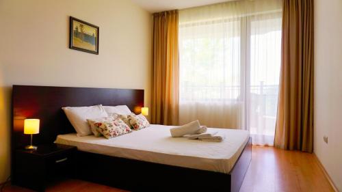 a bedroom with a large bed with a window at Бяла Виста Бийч Апартментс B - Byala Vista Beach Apartments B in Byala