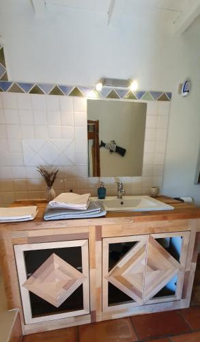a kitchen counter with a sink and a mirror at Aux berges du pont du gard in Vers Pont du Gard